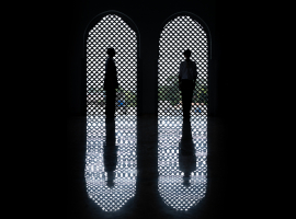 Siluet dua orang berdiri berhadapan di depan jendela melengkung dengan pola anyaman Islami, terpantul di lantai gelap yang mengilap, menciptakan komposisi simetris dan suasana tenang